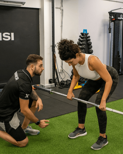 Andreas coaching a client through a barbell row at STMAC Studio